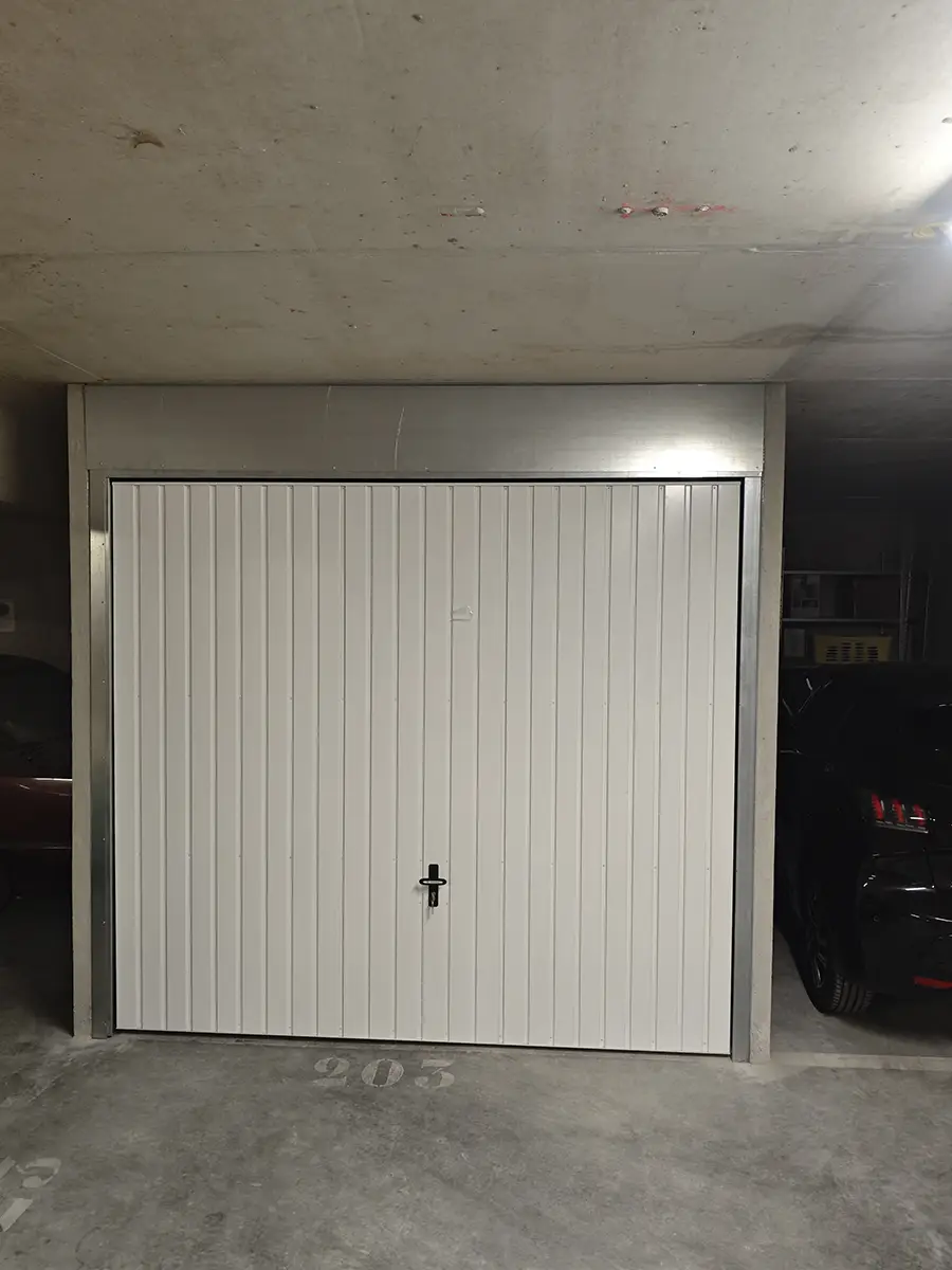 Porte de garage basculante blanche fermée avec habillage galvanisé à Cannes